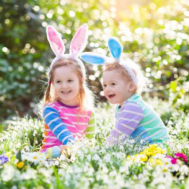 Çocuklar çiçeklenme içinde Paskalya yumurtası avına Bahçe bahar