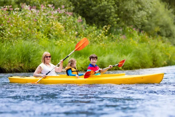 Familjen njuter av kajak tur på en flod — Stockfoto