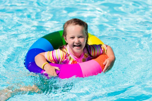 Liten flicka med leksak ring i poolen — Stockfoto