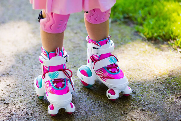Little girl with roller skate shoes in a park