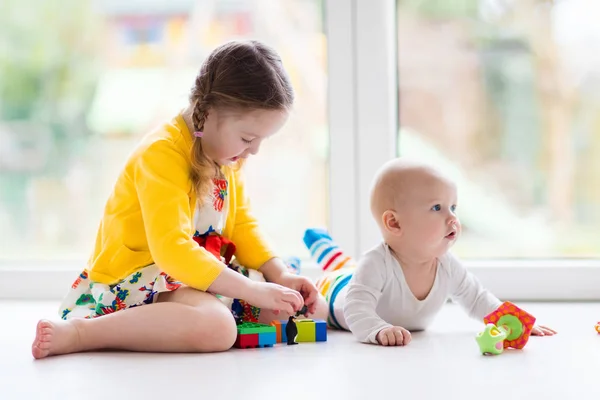 Hermana y hermanito juegan con bloques de juguetes — Foto de Stock