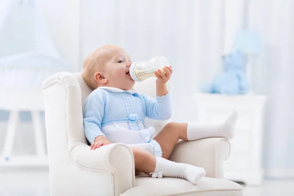 Baby boy with bottle drinking milk or formula