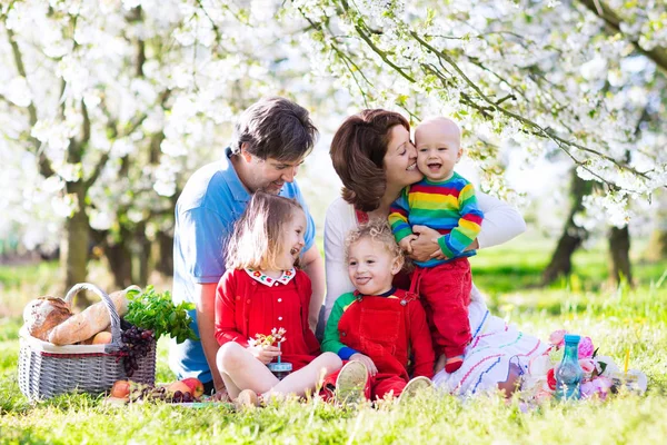 Familj med barn på picknick i vårträdgård — Stockfoto