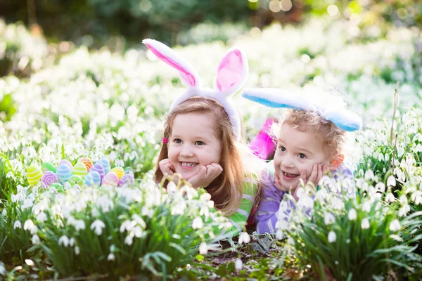 Діти на Великдень полюють у квітучому весняному саду — стокове фото