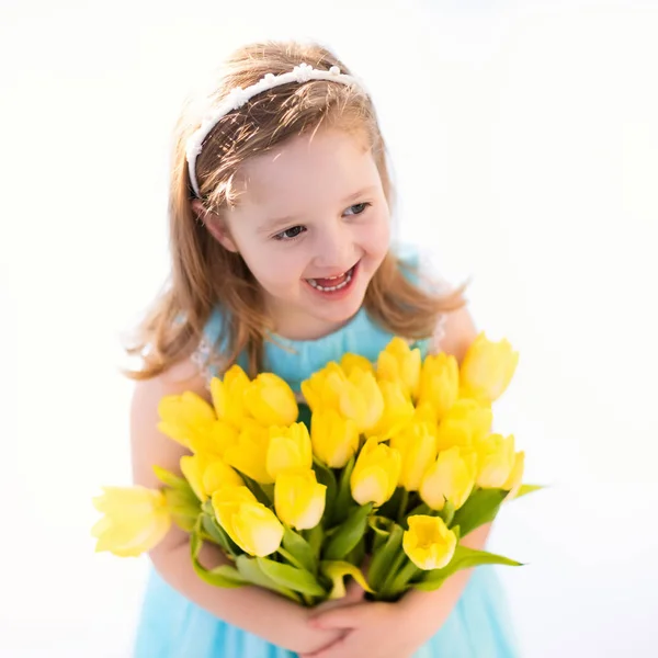 Kleines Mädchen mit Tulpenblumenstrauß — Stockfoto