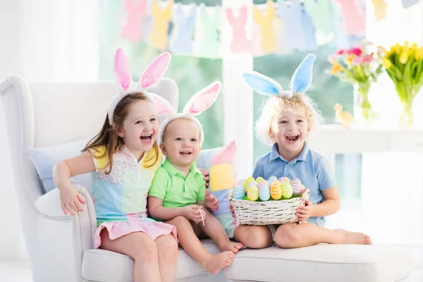 Enfants avec des oreilles de lapin sur la chasse aux œufs de Pâques — Photo