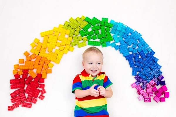Criança brincando com arco-íris blocos de plástico brinquedo — Fotografia de Stock
