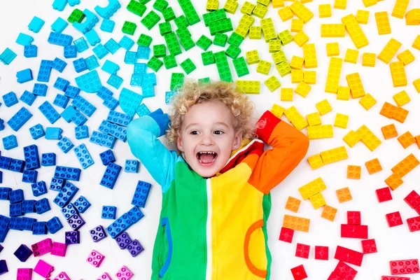 Child playing with rainbow plastic blocks toy — Stock Photo, Image