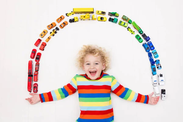 Niño jugando con coches de juguete. Juguetes para niños . — Foto de Stock