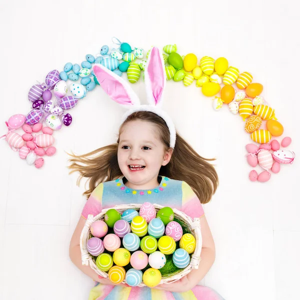 Dziecko na Easter egg hunt. Rainbow Pastelowe jajka. — Zdjęcie stockowe