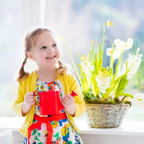 Küçük kız sulama bahar çiçekleri — Stok fotoğraf