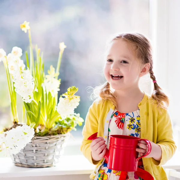 Liten flicka vattning vårblommor — Stockfoto