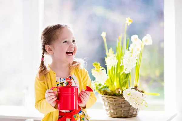 Liten flicka vattning vårblommor — Stockfoto