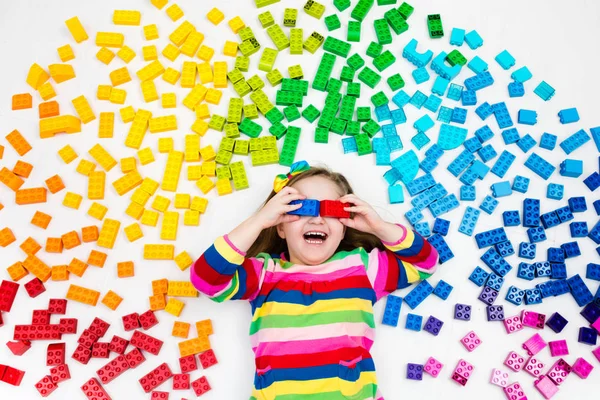 Criança brincando com arco-íris blocos de plástico brinquedo — Fotografia de Stock