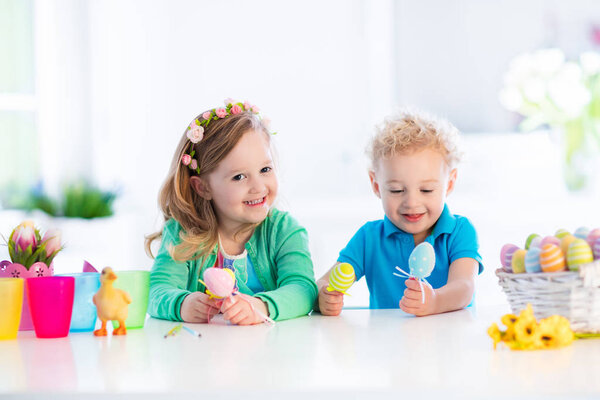 Kids with colorful Easter eggs on egg hunt