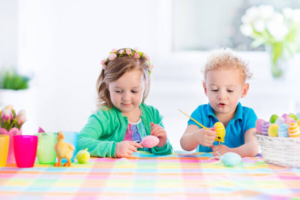 Kids with colorful Easter eggs on egg hunt