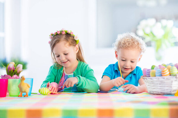 Kids with colorful Easter eggs on egg hunt