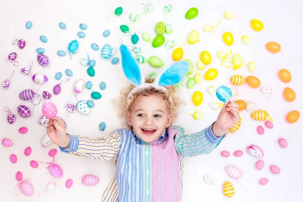 Ребенок на пасхальных яйцах. Пастельные радужные яйца . — стоковое фото