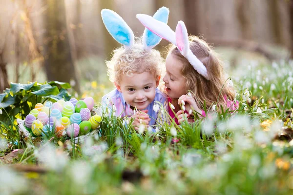 Діти на Великдень полюють у квітучому весняному саду — стокове фото