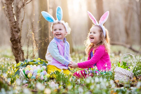 A gyerekek a húsvéti tojás vadászat virágzó tavaszi kert — Stock Fotó