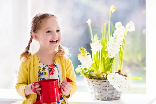 Niña regando flores de primavera — Foto de Stock