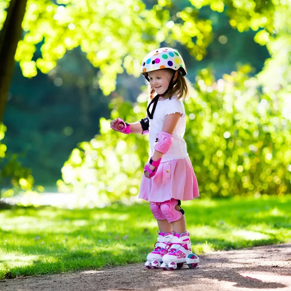 Liten flicka med roller skateskor i en park — Stockfoto