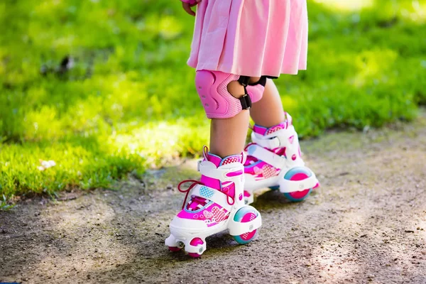 Liten flicka med roller skateskor i en park — Stockfoto