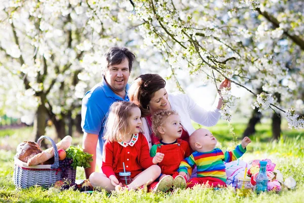 Familj med barn på picknick i vårträdgård — Stockfoto