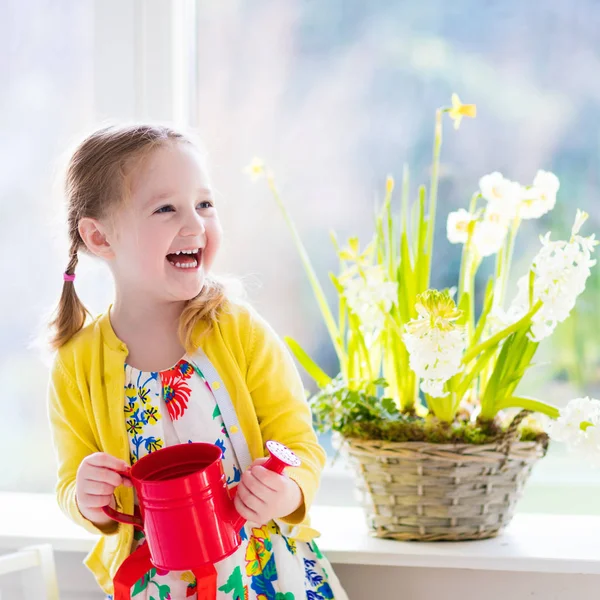 Mała dziewczynka podlewania wiosennych kwiatów — Zdjęcie stockowe