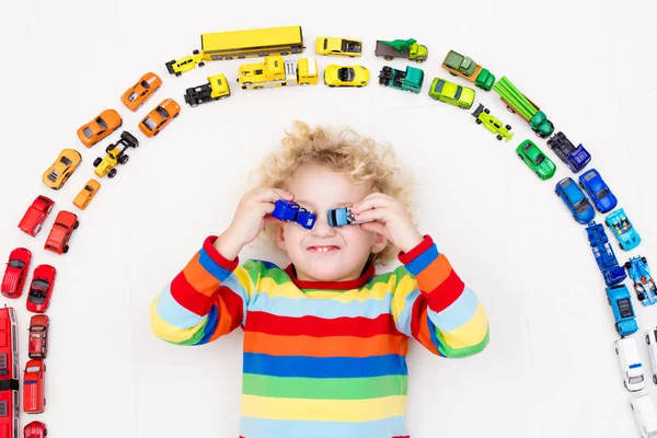 小さな男の子がおもちゃの車で遊んでいます。子供のためのおもちゃ. — ストック写真