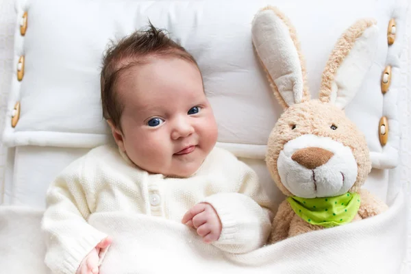 Bebê na cama com coelho brinquedo — Fotografia de Stock