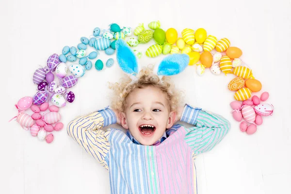 Ребенок на пасхальных яйцах. Пастельные радужные яйца . — стоковое фото