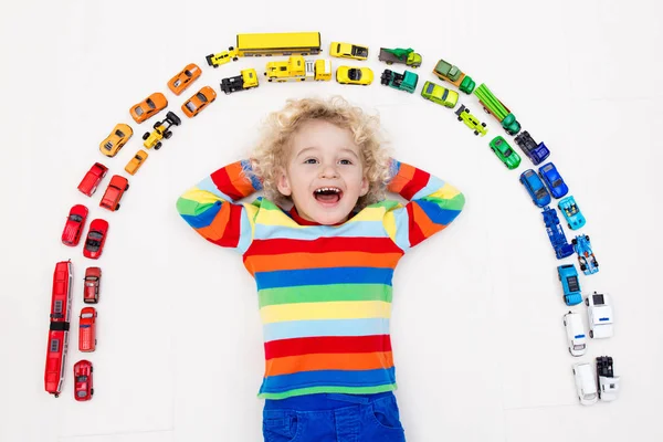 Ragazzino che gioca con le macchinine. Giocattoli per bambini . — Foto Stock