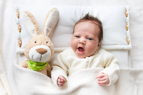 Bebê na cama com coelho brinquedo — Fotografia de Stock