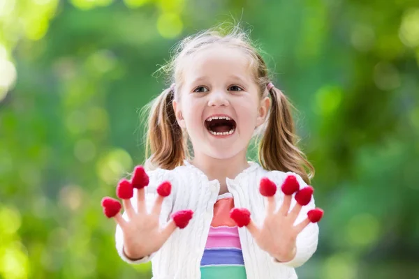 Child picking and eating raspberry in summer — Stock Photo, Image