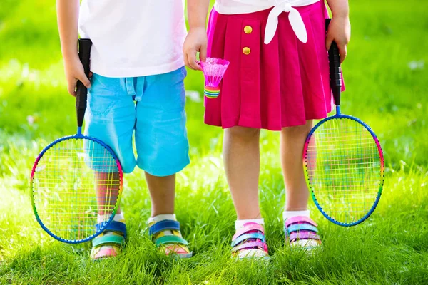 เด็ก ๆ เล่นแบดมินตันหรือเทนนิสในสนามกลางแจ้ง — ภาพถ่ายสต็อก