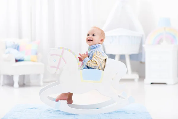 Baby boy in rocking horse toy