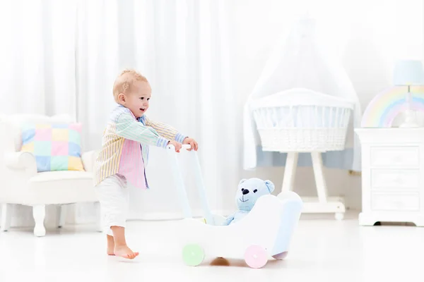 Bebé con caminante push en dormitorio blanco — Foto de Stock