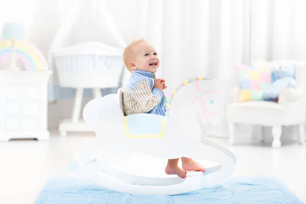 Baby boy in rocking horse toy