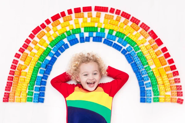 Niño jugando con arco iris bloques de plástico juguete — Foto de Stock