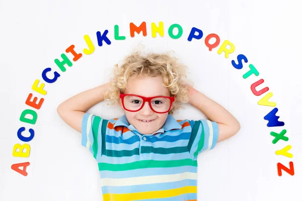 アルファベットと読みの文字を学習する子 — ストック写真