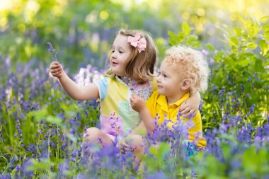 Bluebell çiçekler Çiçek bahçesinde oynayan çocuklar