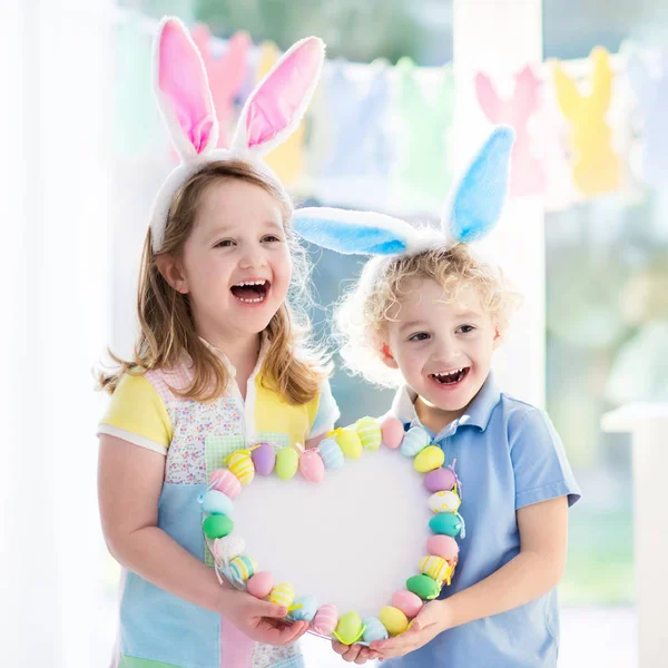 Crianças em orelhas de coelho na caça ao ovo de Páscoa — Fotografia de Stock