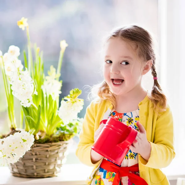 Niña regando flores de primavera — Foto de Stock