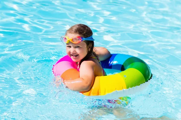 Liten flicka med leksak ring i poolen — Stockfoto