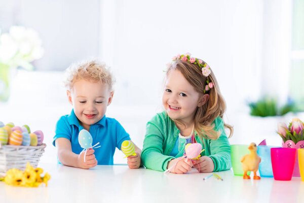 Kids with colorful Easter eggs on egg hunt