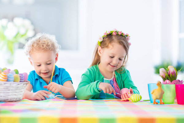 Дети с разноцветными пасхальными яйцами на охоте за яйцами
