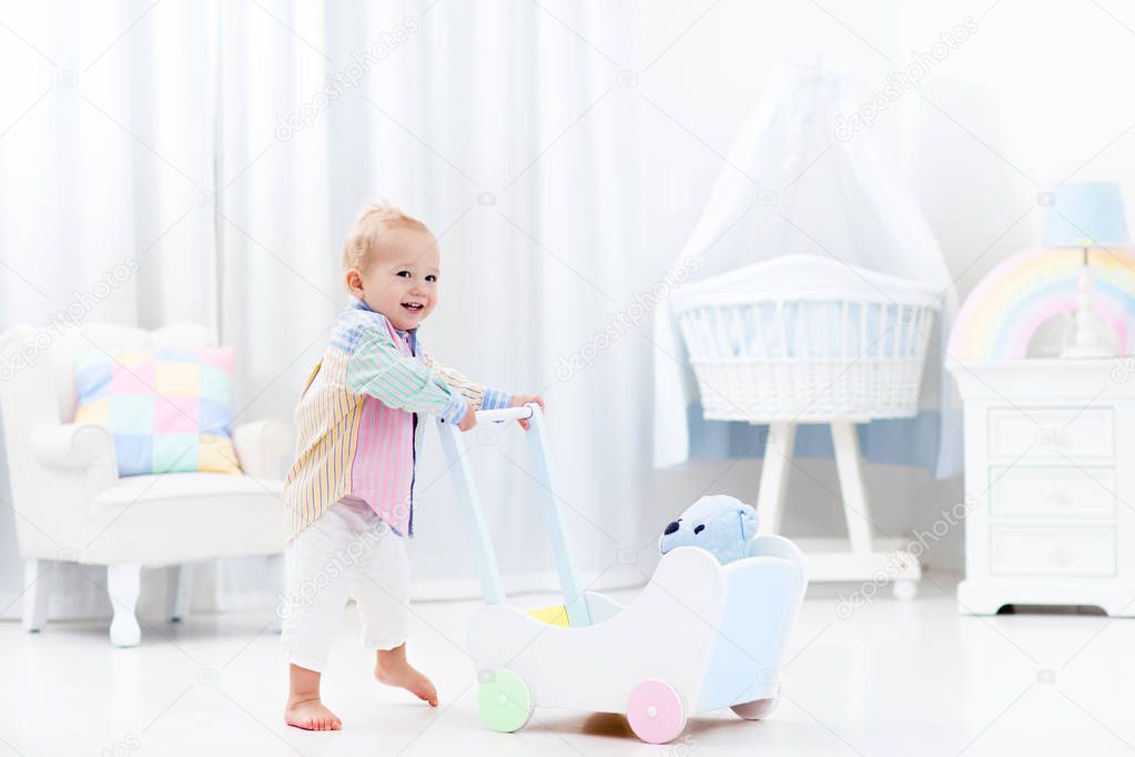 Baby with push walker in white bedroom