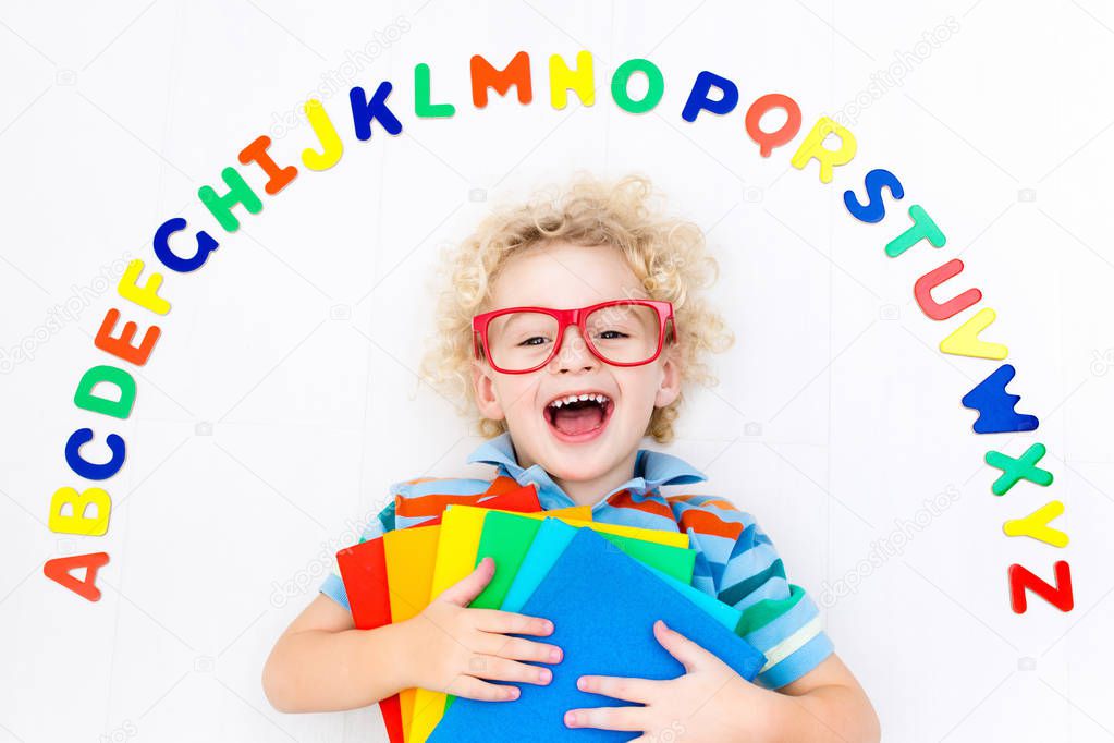 Child learning letters of alphabet and reading