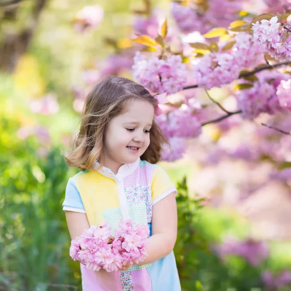 Liten flicka med körsbärsblommor — Stockfoto